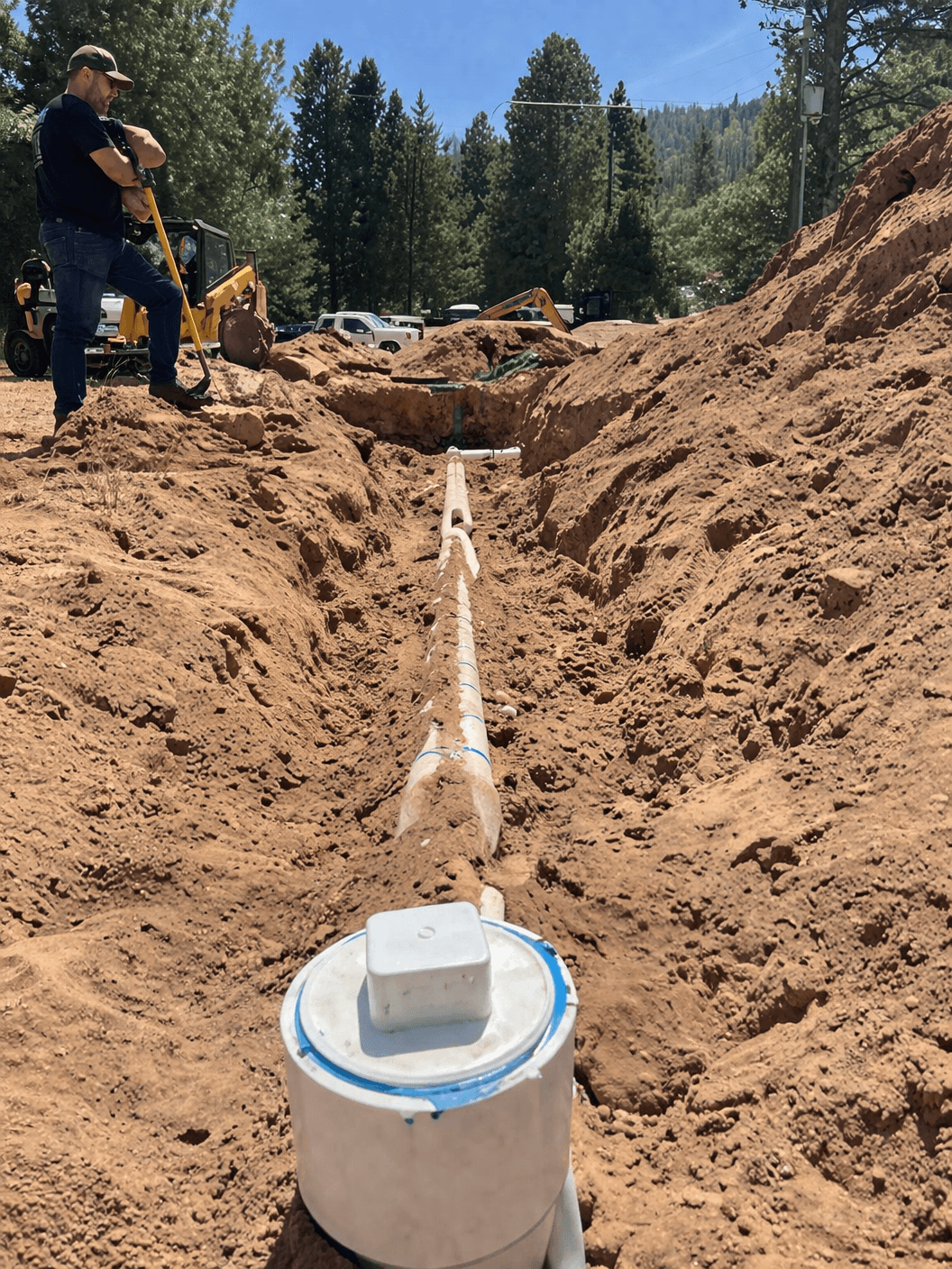 Drainfield installation trench with piping and inspection components.