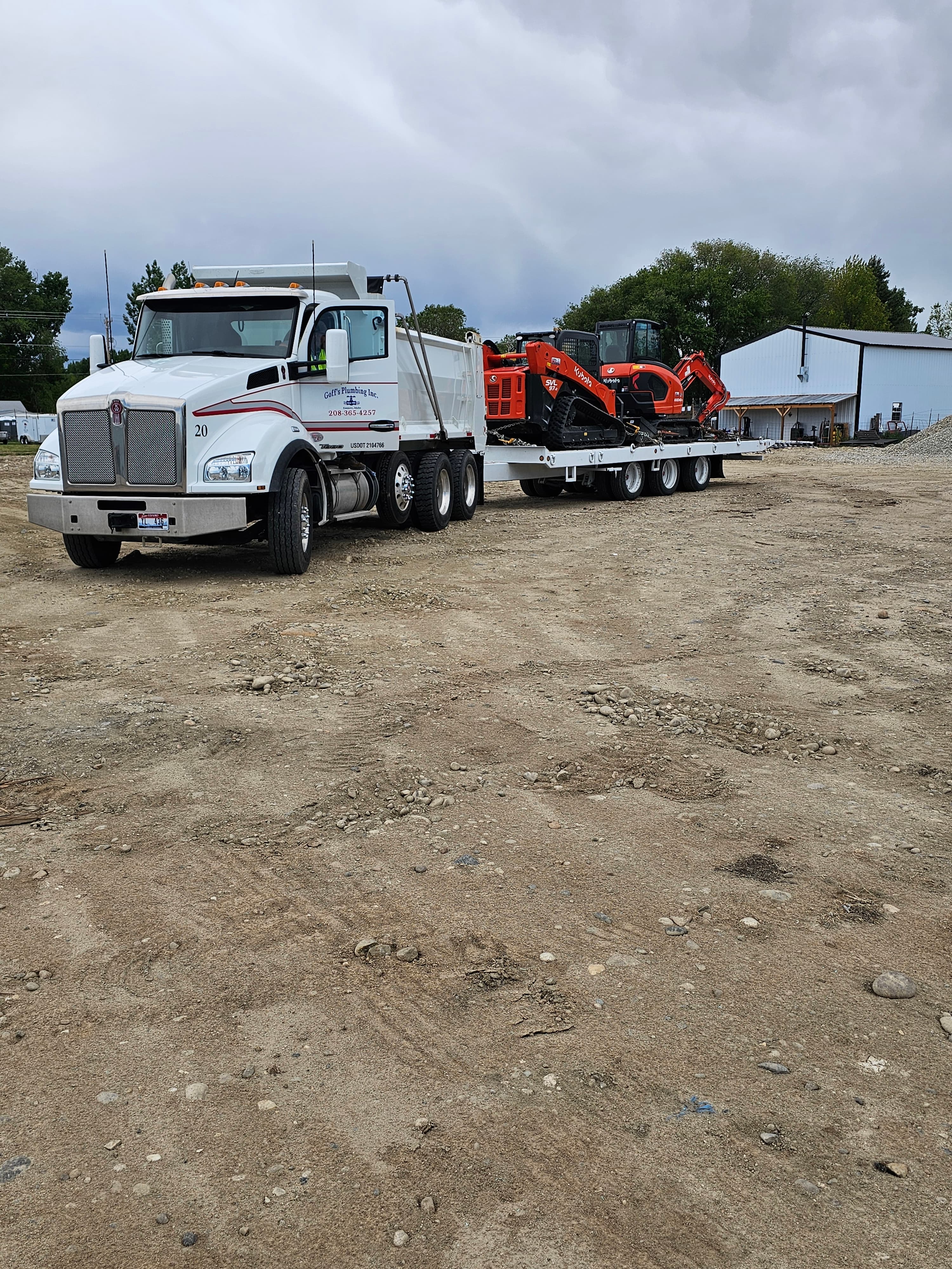 Goff's Plumbing, Inc. truck hauling heavy excavation equipment to the next jobsite.