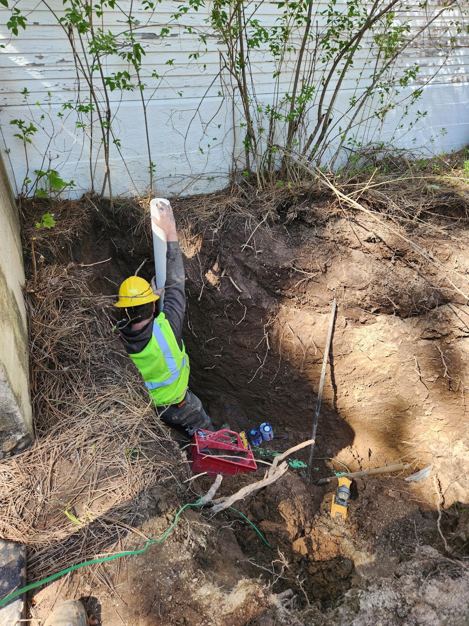Crew member performing excavation repair work for an underground line.